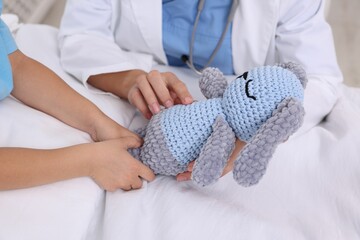 Canvas Print - Doctor examining little girl on bed at hospital, closeup