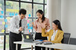 © Kritdanai - Successful Collaboration:  A team of smiling professionals celebrates a successful project milestone in a modern office setting, displaying a sense of unity and accomplishment.