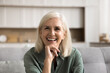 © fizkes - Head shot happy mature female relaxing seated on sofa laughing looking at cam, feel satisfied enjoy moment of peacefulness and quiet weekend leisure alone at modern flat. Older female home portrait