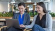 © Hopeful Day - Two professional women collaborate on a project, smiling while working together on a laptop.