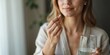 © Helen Marlen - woman taking pill with glass of water