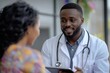 © Pooja - Young black doctor consulting woman in clinic pointing at tablet screen, Generative AI