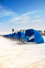 photo of a beach with sun loungers, sandy beach with places for rest, family vacation at sea or ocean