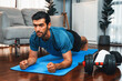 © Summit Art Creations - Athletic and sporty man doing plank on fitness mat during home body workout exercise session for fit physique and healthy sport lifestyle at home. Gaiety home exercise workout training.
