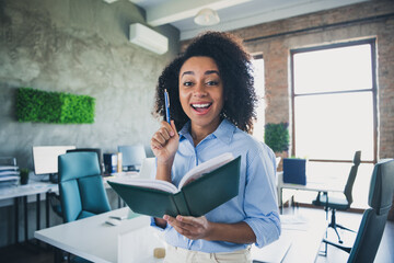 Poster - Photo of excited positive lady broker wear shirt smiling writing notebook indoors workplace workshop