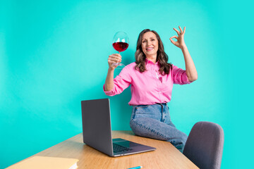 Wall Mural - Photo portrait of lovely pensioner lady working office enjoy wine okey dressed stylish pink garment isolated on aquamarine color background