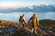 © EVERST - Couple with backpacks hiking in Norway mountains man and woman holding hands traveling active vacations healthy lifestyle outdoor family adventure extreme trip friends climbing Lyngen Alps