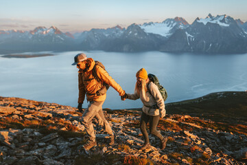 Poster - Couple hiking in mountains friends holding hands climbing together active vacations in Norway healthy lifestyle outdoor, family adventure trip man and woman exploring Lyngen Alps, adventure endurance