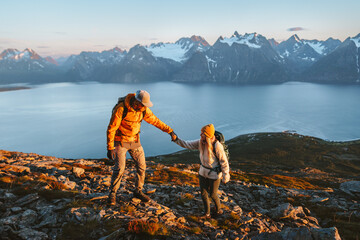 Poster - Couple hiking in mountains man giving helping hand woman, active vacations in Norway healthy lifestyle outdoor family adventure trip friends climbing in Lyngen Alps