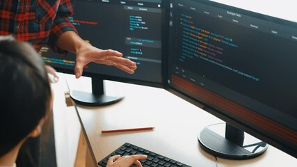 Back end or software developer manager supervising his team on new application program development on debugging and solving complex code algorithms on monitor. Burgeoning