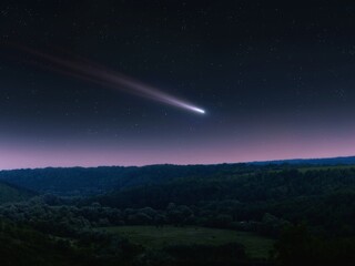 comet tail in the sky, night landscape. comet surrounded by stars over hills. astrophotography of a 