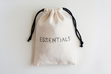 minimalist cotton drawstring bag labeled 'essentials' on white background
