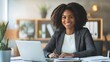 © sungedi - Smiling Black Woman Working at a Desk with a Laptop