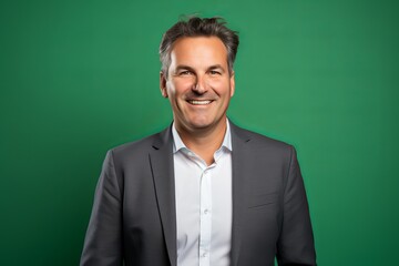 Poster - Handsome middle aged man with grey hair smiling and looking at camera against green background