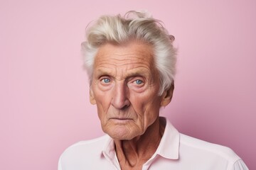 Portrait of senior woman looking at camera with sad expression, isolated over pink background