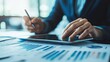© arthit - Investor reviewing financial reports and data trends, using a tablet to plan business expansion and increased profits in a bright office environment. Copy space.