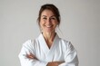 © LimeSky - Middle aged woman in karate uniform smiling with arms crossed looking at the camera Positive demeanor