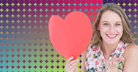 Canvas Print - Caucasian woman holding a heart shaped placard against colorful background with copy space