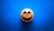 © Malon - A smiley emoji ball on a blue background symbolizing Blue Monday, reflecting themes of happiness, emotion, and melancholy.