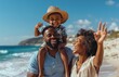 © Georgii - Happy Black family enjoying a sunny day at the beach with father carrying son on shoulders and mother cheerfully waving