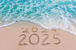 © MAITREE - Message Year 2024 replaced by 2025 text written on beach sand background. Good bye 2024 - 2025 happy New Year coming concept.  top view.