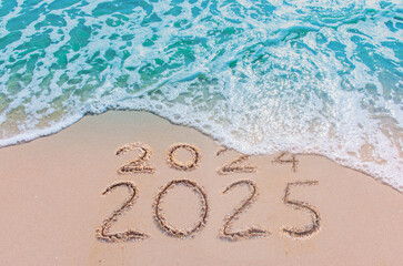 message year 2024 replaced by 2025 text written on beach sand background. good bye 2024 - 2025 happy