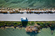 © Cavan Images - Drone top view of a camper van on a road between two lakes