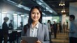 © Prapan - Confident Asian businesswoman smiles proudly, dressed in business attire,