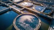 © Tomass - Large outdoor wastewater treatment plant with circular tanks reflecting sunlight in the morning
