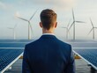 © Preeyanuch - A businessman overlooks renewable energy sources, featuring solar panels and wind turbines, symbolizing sustainability and innovation.