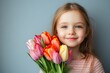© Michael - Adorable little girl is holding a bouquet of beautiful orange tulips
