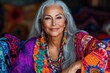 © Nena Photo - Elegant elderly woman with long gray hair in vibrant bohemian ethnic clothing, embodying wisdom, grace, and cultural diversity, with a serene smile.