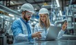© Rajiv - Male and Female Industrial Engineers in Hard Hats Discuss New Project while Using Laptop. They Make Showing Gestures.They Work in a Heavy Industry Manufacturing