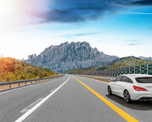 Wall Mural - The car is driving along the highway surrounded by picturesque nature.