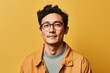 © Loli - Portrait of handsome asian man in yellow jacket and glasses on yellow background