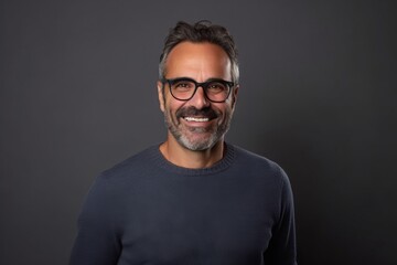 Portrait of a smiling middle-aged man with eyeglasses against grey background