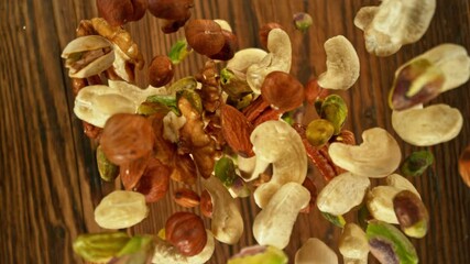 Poster - Super Slow Motion of Flying Nuts Mix over Wooden Planks. Camera Tracking the Target. Filmed on High Speed Cinema Camera, 1000fps.