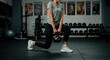 © Margareta - Fitness Enthusiast Performing Lunges with Kettlebell in Gym
