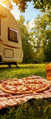 Delicious pizza on picnic blanket, caravan in background, sunny outdoor setting.