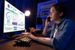 © Summit Art Creations - Young beautiful Asian creative woman calling on phone to customer or coworker informing strategy marketing creator plan while searching market analysis on pc at neon modern office at night. Stratagem.