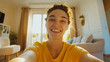 © KoralFox - Cheerful young woman taking a bright selfie in a cozy living room with sunlight streaming in
