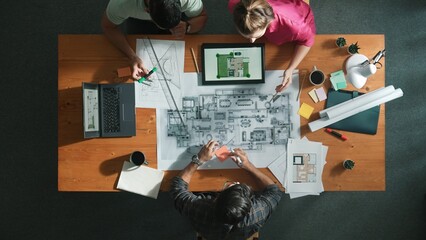 Top down view of civil engineer handed document while looking at blueprint. Aerial view of architect team brainstorming idea and planning building design while sitting at table with plan. Symposium.