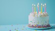 © ADD PHOTO - Vibrant Birthday Cake with Colorful Candles and Sprinkles on Turquoise Background