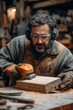 © Design Dynasty - Man using electric sander on wooden block in workshop filled with tools and gadgets. Concentrating while standing at workbench in woodworking setting with shelves in, Generative AI