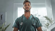 © Flyura Shakembekova - Confident young male nurse in scrubs with stethoscope standing in a well-lit medical room