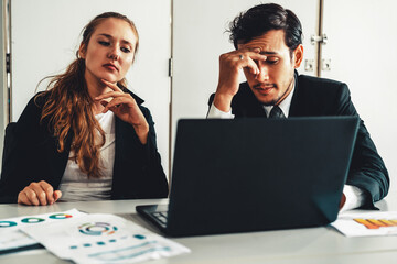 unhappy serious businessman and businesswoman working using laptop computer on the office desk. bad 