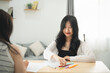 © WMSTUDIO - A woman is sitting at a table with a piece of paper and a box of markers