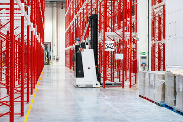 Red white racking system with forklift inside warehouse selective focus photography