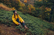 © SHOTPRIME STUDIO - Beautiful young woman in yellow jacket sitting alone on grassy hill surrounded by autumn forest serene nature getaway fashion photo concept