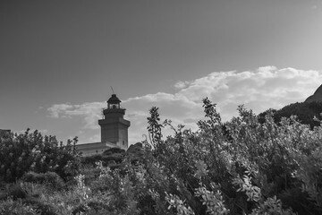 lighthouse over sea cliffs of capo testa in northern sardinia region, italy